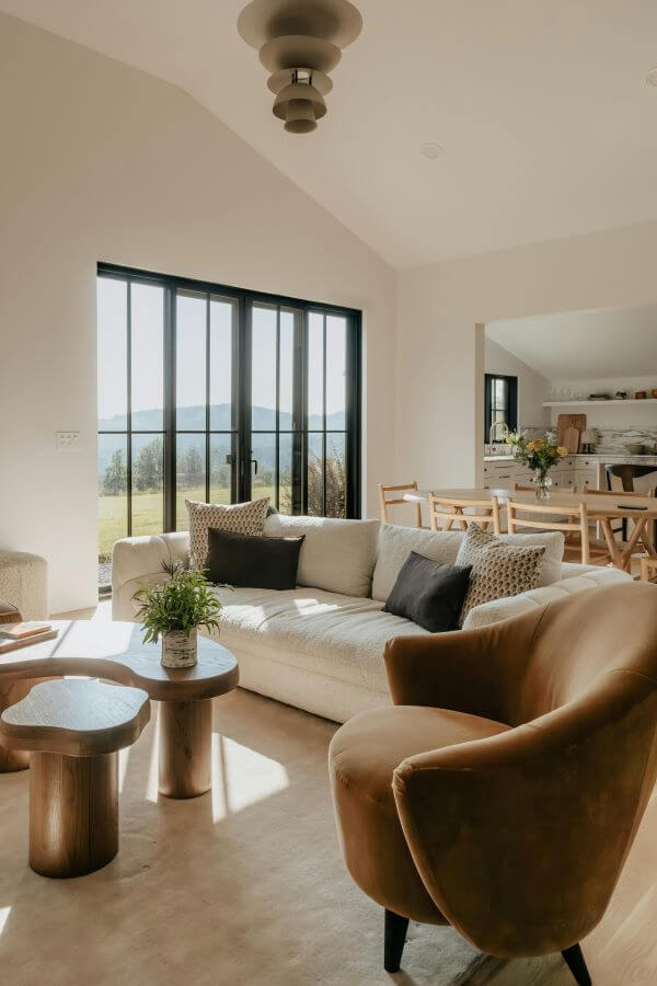 Salon lumineux avec grande fenêtre, illustrant l’importance de la lumière dans une déco naturelle et durable