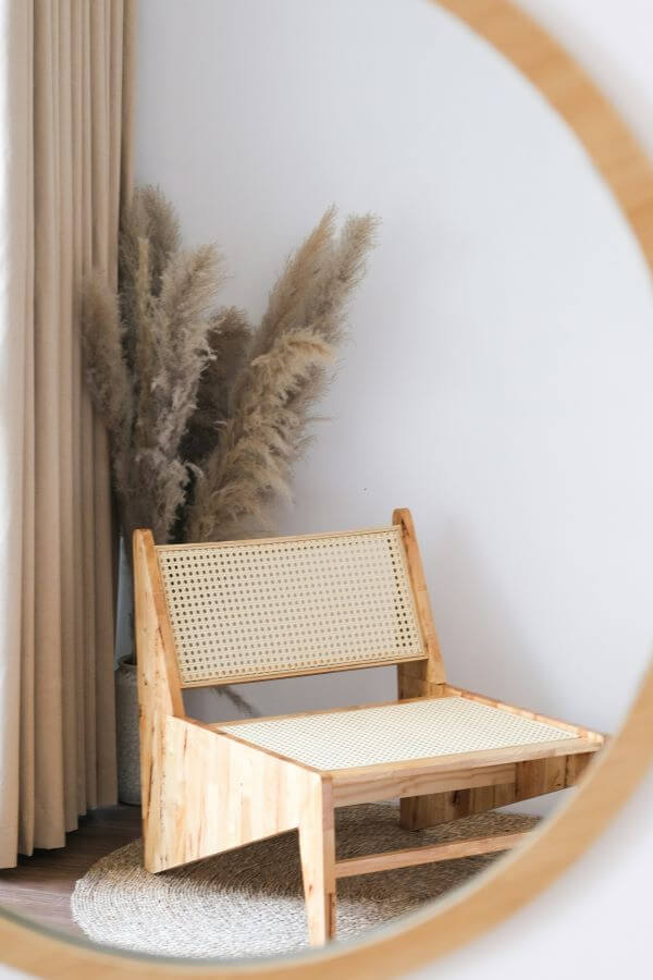 Fauteuil, pampa et teintes neutres reflétées dans un miroir, illustration d’une déco naturelle signée décoratrice d’intérieur Oise et Yvelines