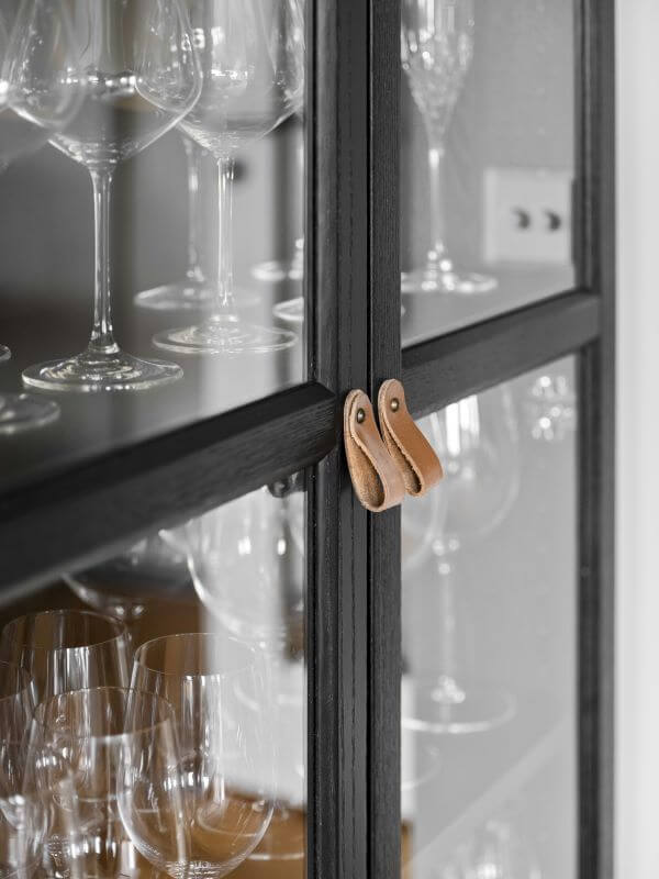 Vaisselier relooké en noir avec poignées en cuir, exemple de déco naturelle et durable réalisée par une décoratrice d’intérieur dans les Yvelines